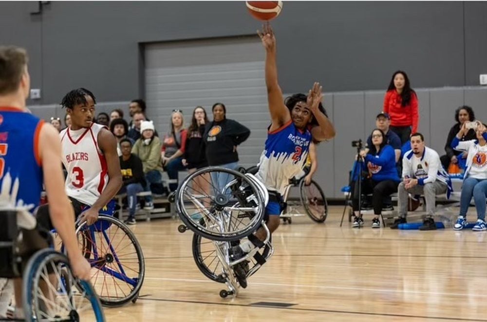 A Rolling Fury player shooting a layup during a game as opposing players and a crowd look on